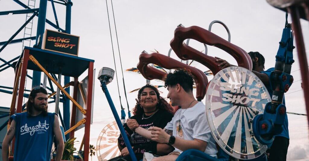Two friends riding the Sling Shot at an amusement park in Kissimmee, Florida, with a vibrant sunset backdrop.