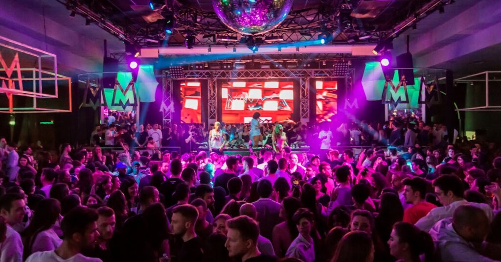 Dynamic crowd at a lively nightclub in Mantua, Italy, with vibrant lights and energetic atmosphere.