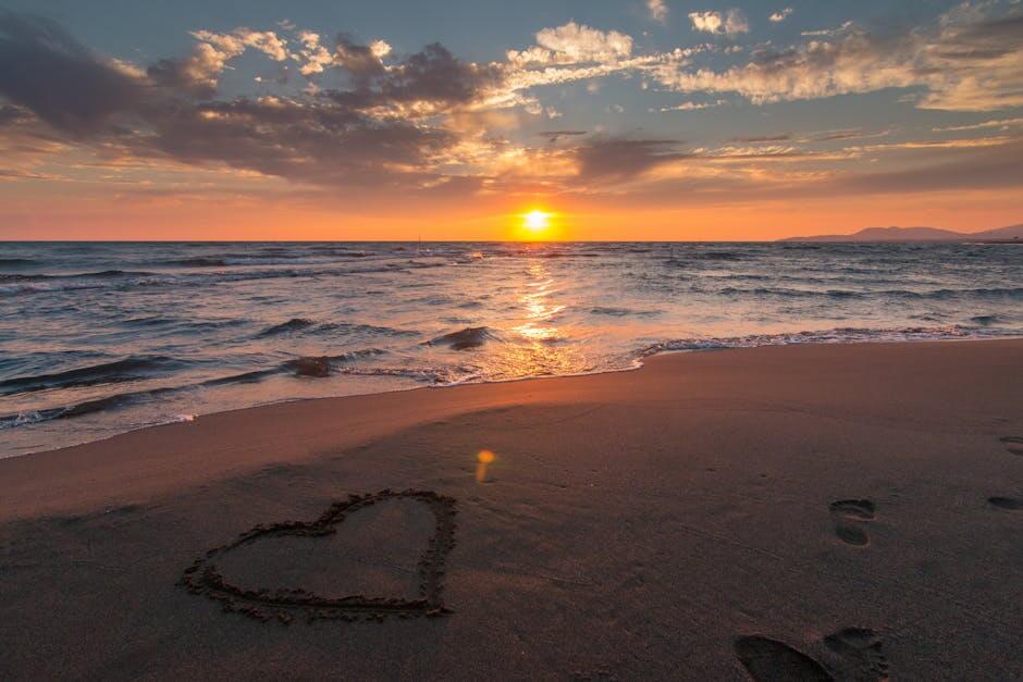 pexels-photo-269583-269583-1 Beautiful sunset over ocean with a heart shape in the sand, perfect for romantic themes.