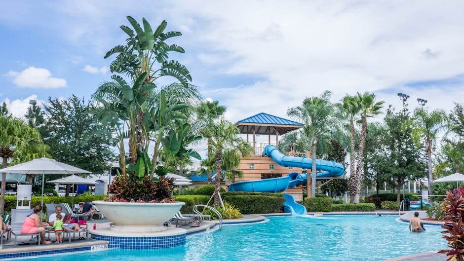 pexels-photo-261429-261429 Vibrant tropical resort scene featuring a pool, waterslide, and lush palm trees, ideal for summer vacations.