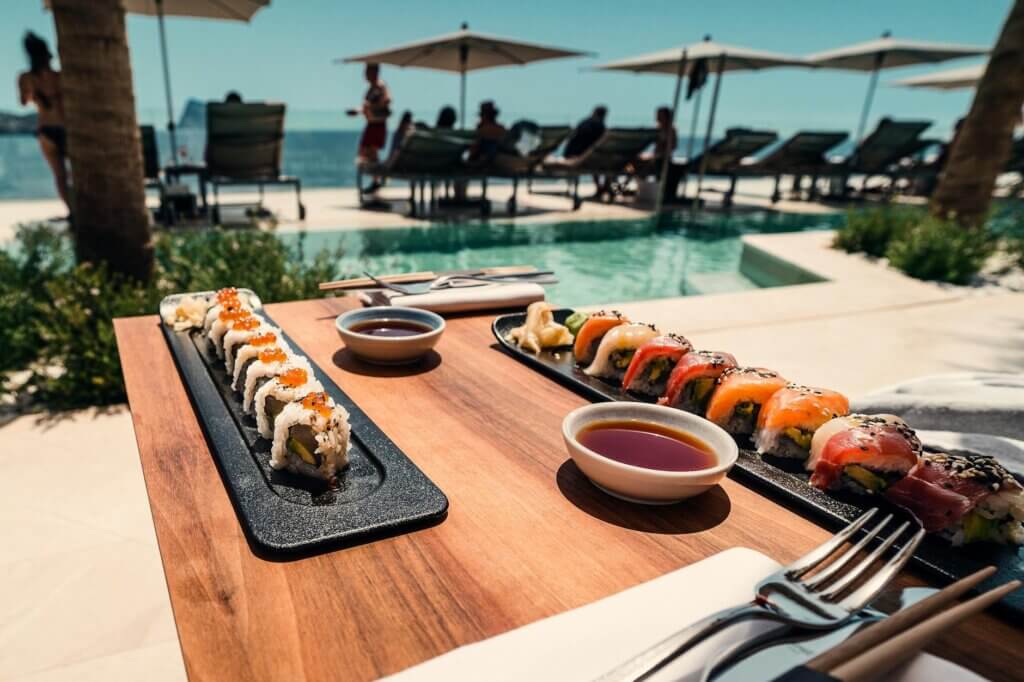Delicious sushi rolls served by a poolside in sunny Ibiza, perfect for a summer vacation dining.