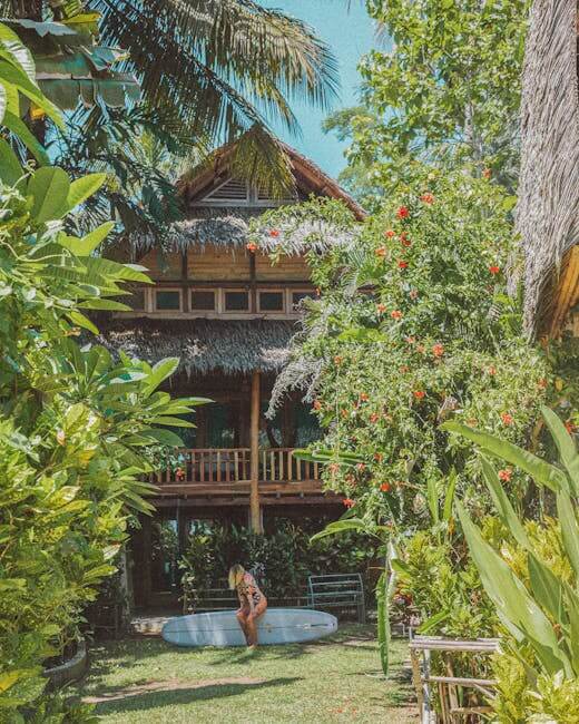 Beautiful tropical villa surrounded by lush greenery and a surfboard, perfect for a luxury vacation.