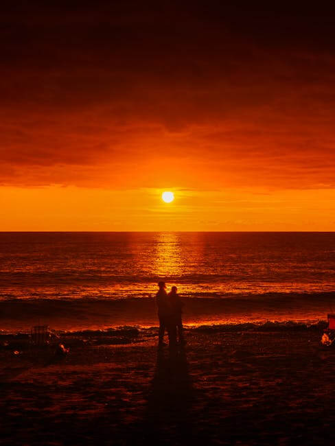 Couple enjoying a vivid sunset on Mahmutlar Beach, Antalya, Turkey.