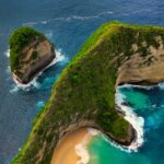 Stunning aerial view of Kelingking Beach in Bali, showcasing turquoise waters and dramatic cliffs.